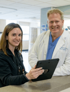 Dr. Reynolds with Nurse looking at chart on tablet