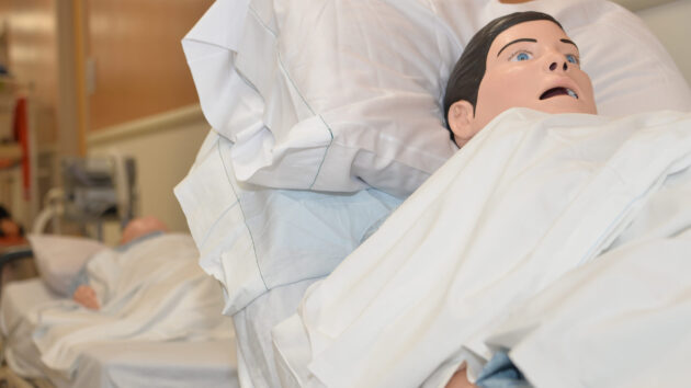 Simulation dummy laying in a hospital bed