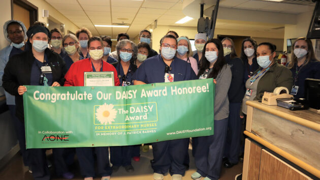 Labor and Delivery unit holds DAISY Award banner recognizing nurse Kathryn Dupuis