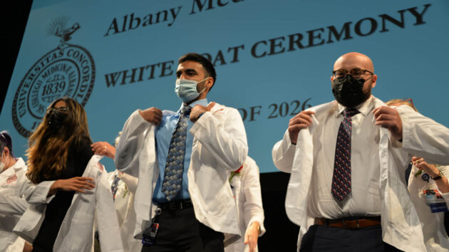 Students from the Albany Medical College class of 2026 putting on their white coats