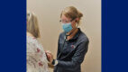 Cindy Coons, PA-C, '13, listens to a patient's breathing with a stethoscope