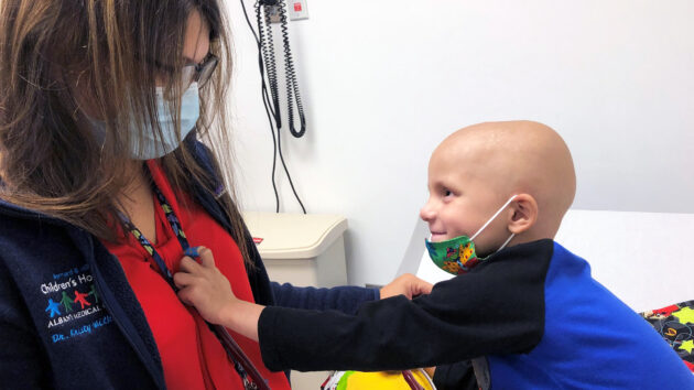 Young patient holds a stethoscope to the doctor's chest to listen to her heart