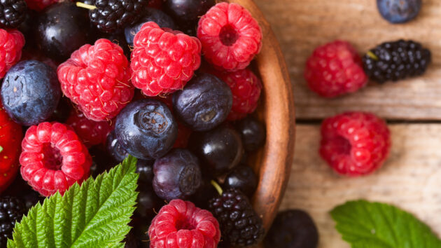 Healthy raspberries and blueberries in a bowl.