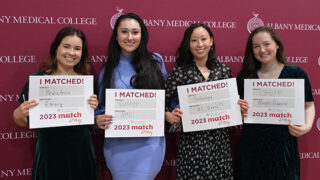 Group of medical students displaying their residency Match Day cards.