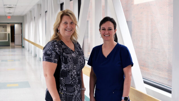 Ruth Jameson, MS, RN, CRNI, nurse manager, and Lorrai Carpenter, RN, lead clinical nurse at the Glens Falls Hospital Infusion Center standing in hallway of Albany Medical Center.
