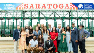 Guests at Light Up the Night, Albany Med's annual summer fundraising gala, pose in front of the gate at Saratoga Race Track