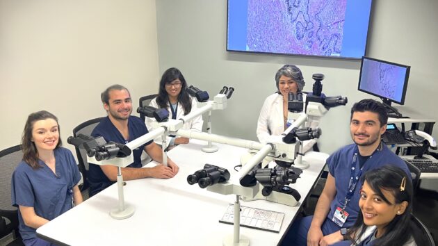 Nada Farhat, MD, ocular pathologist, with residents at a multi-scope microscope within the Department of Pathology at Albany Medical Center.