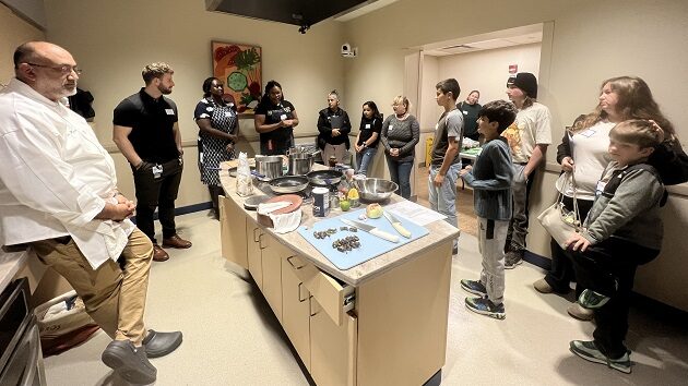 children and parents gather around a kitchen for the dining with diabetes cooking class