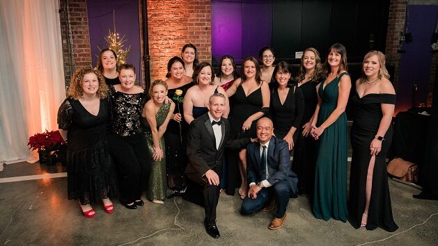 Melodies Center doctors and nurses in formal attire pose together at the Dancing in the Woods gala