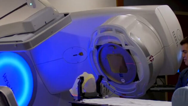 Medical technicians operating a radiation therapy machine
