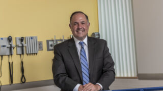 Dr. Jason Mouzakes, Albany Medical Center Hospital General Director, standing in a hospital patient room.