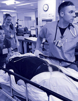 Clinicians transporting a patient through the emergency room