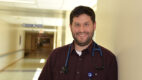 Infectious disease specialist Dr. Benjamin Tack standing in a hospital hallway