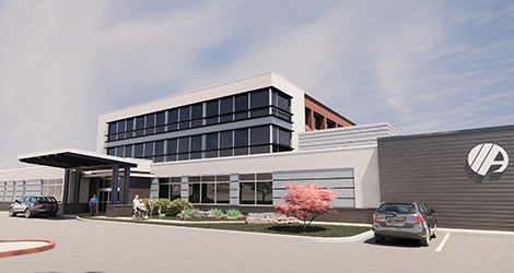 Car sitting in a parking lot outside of a health care building under a cloudy blue sky.