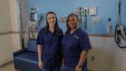 Two clinicians standing in a hospital room.