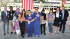 A dozen employees in front of a flag during the citizenship day ceremony