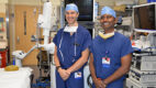 Thoracic surgeon Dr. Brian Arnold and interventional pulmonologist Dr. Nagendra Madisi standing in an operating room wearing blue scrubs