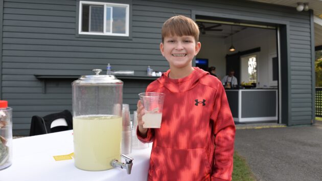 Ethan, our 2025 Miracle Child Champion, handing out lemonade to golfers.