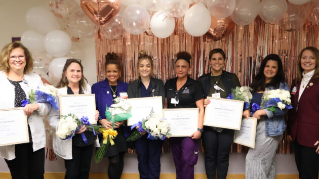 A group of seven nurses receiving an award for excellence