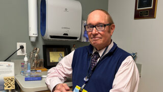 Endocrinologist Dr. Robert Busch sitting in a patient exam room