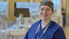 Dr. Sandra DiBrito smiling with technological equipment in the background