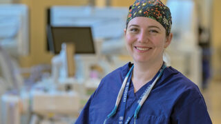 Dr. Sandra DiBrito smiling with technological equipment in the background