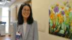 Urologist Dr. Lara MacLachlan standing next to a painting of flowers in a hallway in the urology clinic