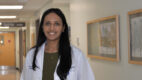 Gastroenterologist Dr. Anika Paradkar wearing a white coat standing in a clinic hallway